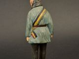 figurine of a man in a blue uniform with a red hat on a wooden base