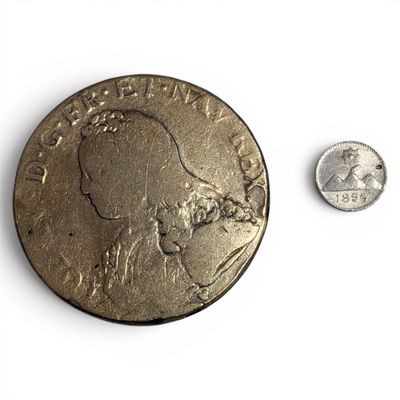 a coin and a dime on a white surface