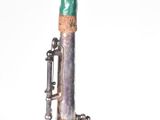 a silver and green instrument that is sitting on a table