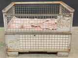 a cage with a bed inside of it on the ground