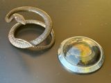 une photo d'un objet en métal sur lequel figure un serpent