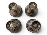 four antique silver salt and pepper shakers on a white surface