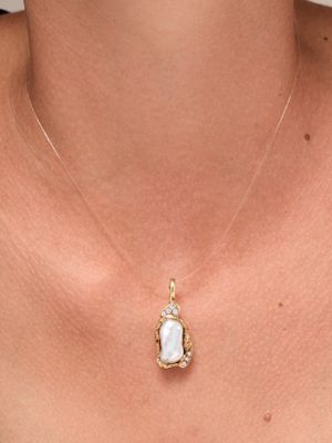 un gros plan d'une femme portant un collier avec un pendentif en forme de cœur