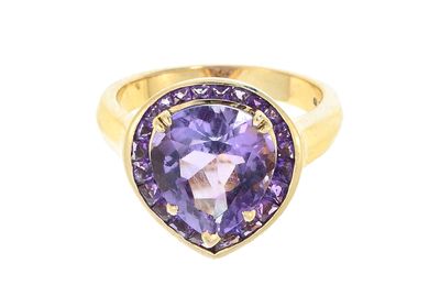 a close up of a gold ring with a purple stone