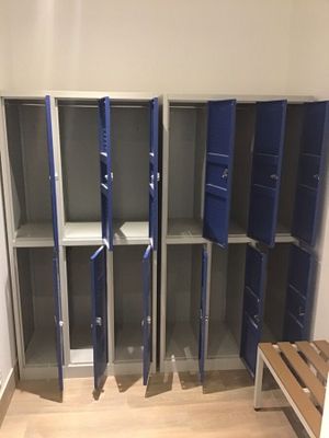 plusieurs casiers dans une pièce où se trouve un banc dans un coin