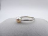 a close up of a ring with a pearl on top of it