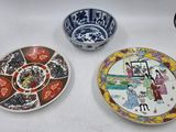 Trois assiettes ornées de motifs asiatiques sont posées sur une table.