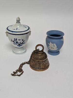 two vases and a bell on a white table