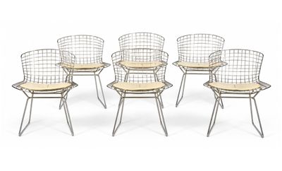 six wire chairs with wooden seat pads on a white background