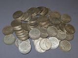 a pile of silver coins on a blue surface