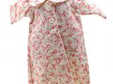 robe à fleurs rose et blanche posée sur un présentoir pour mannequin