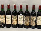 six bottles of wine are lined up in a row on a table