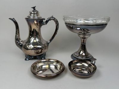 une théière en argent et un bol en argent posés sur une table
