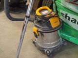 un aspirateur posé par terre à côté d'un sac