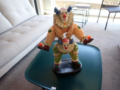 une statue représentant un clown posée sur une table dans un salon