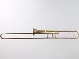a brass trombone with a white background