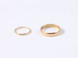 a pair of gold rings on a white surface
