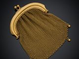un sac à main en maille dorée sur fond noir