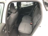 the back seats of a car with a remote control in the passenger seat