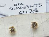 deux paires de boucles d'oreilles en or et diamants posées sur un morceau de papier