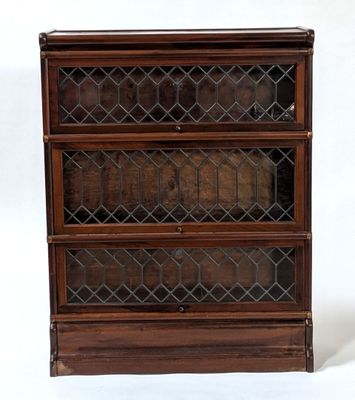 an old wooden bookcase with glass doors on top of it