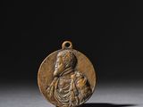 une médaille de bronze représentant une femme tenant un enfant dans ses bras