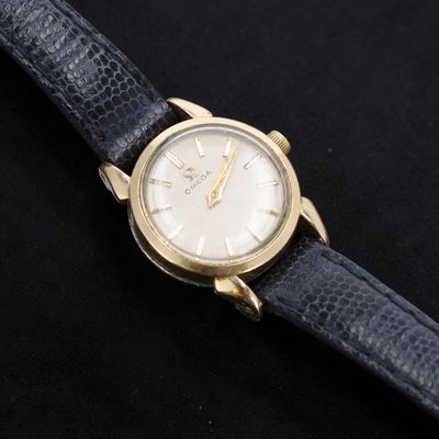 a close up of a watch on a black surface