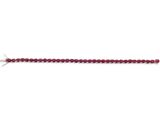 un gros plan d'un bracelet en perles rouges sur fond blanc