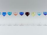 several different colored wine glasses are lined up in a row