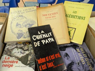 several books in a box sitting on a table in a room