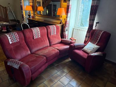 un salon avec un canapé rouge et un fauteuil inclinable rouge