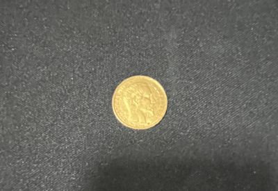a close up of a gold coin on a black surface