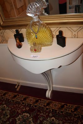 une table blanche sur laquelle se trouvent un miroir et un vase