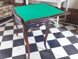 a table with a green cloth on it in the middle of a checkered floor