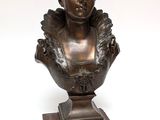 an antique bronze bust of a woman on a wooden base