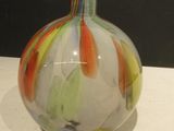 a glass vase with a colorful design on it on a table