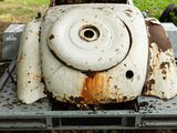 a rusted old car sitting on a table in the grass