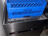 a blue crate that is sitting on top of a dishwasher