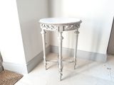 une table blanche avec un plateau en marbre dans une pièce