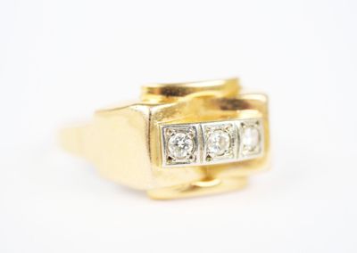 a close up of a gold ring with three diamonds on it