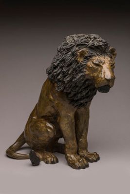 bronze statue of a lion sitting on its hind legs