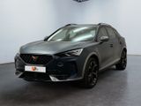 Une voiture grise est garée dans une grande pièce au sol noir.