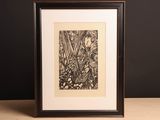 a black and white drawing in a wooden frame on a table