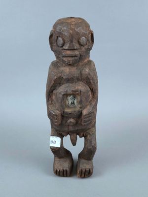 une petite statue en bois représentant un singe tenant une horloge