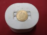 une pièce d'or posée sur un objet blanc