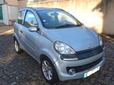 a small silver car parked on a cobblestone street