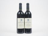 deux bouteilles de vin rouge posées l'une à côté de l'autre sur une surface blanche