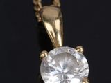 a close up of a diamond pendant on a black surface