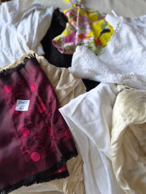 un tas de vêtements posés sur un lit, avec une étiquette dessus