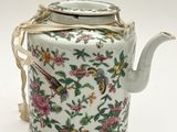 a tea pot with a bird on it on a white surface